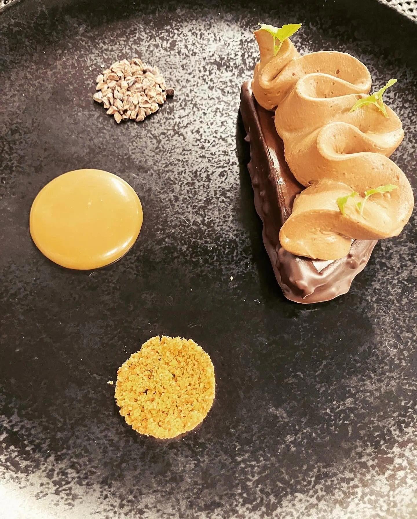 Barre chocolat-caramel et mousse pochée sur plat noir