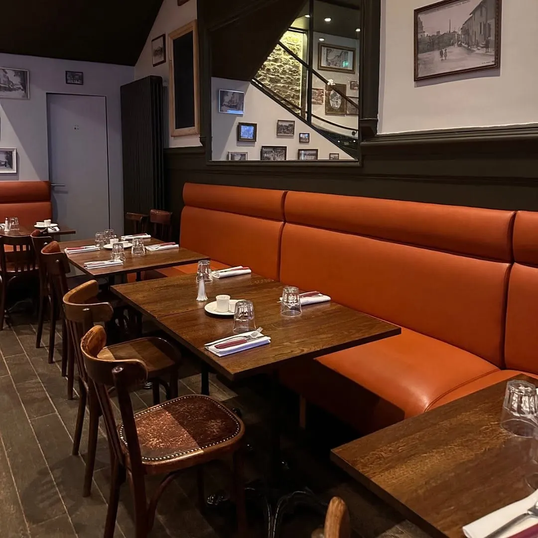 La salle dressée pour le service, banquettes cuir et miroirs