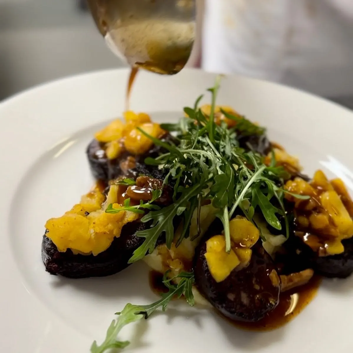 Boudin noir d'Auvergne nappé de jus de viande au moment du service