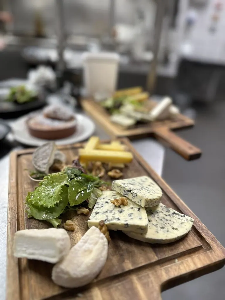Plateau de fromages affinés et noix servi sur planche de bois