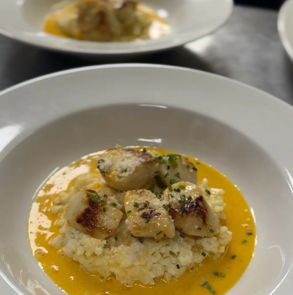 Noix de Saint-Jacques poêlées sur risotto crémeux, sauce corail aux crustacés